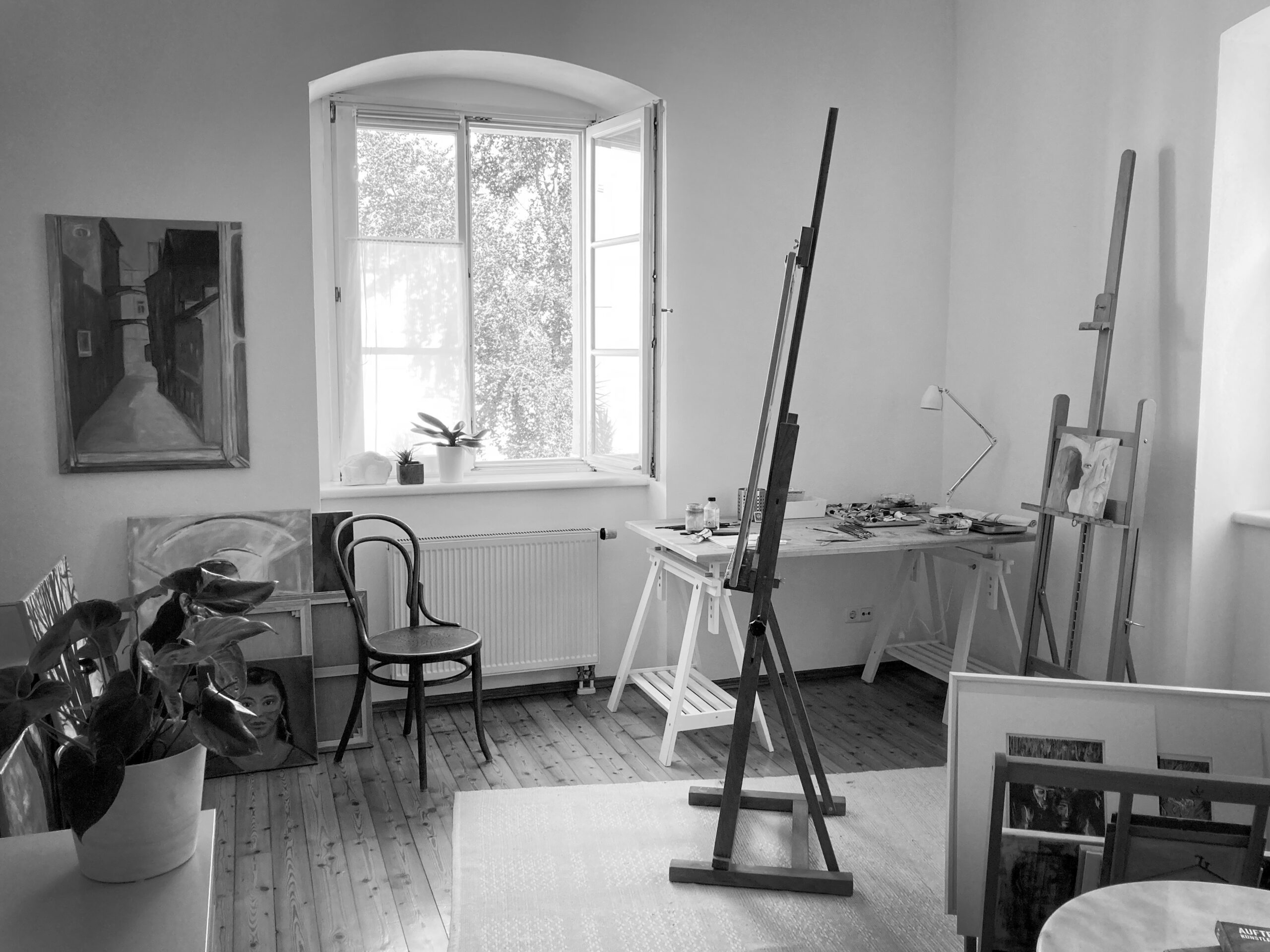 Bild zeigt Atelier-Raum. Es sind eine Staffelei, Gemälde und Pflanzen zu sehen